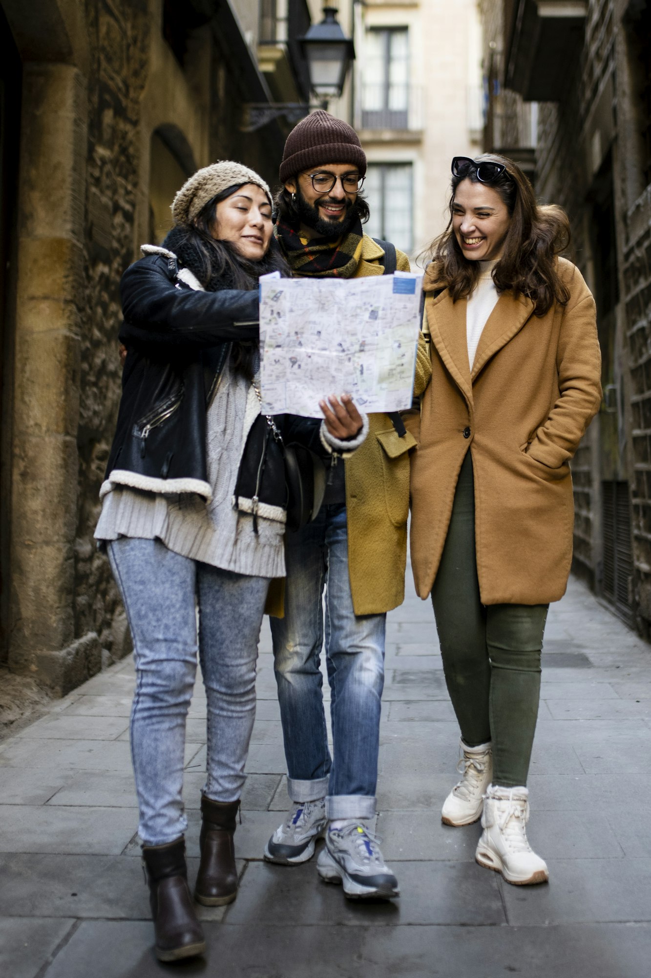 Three multiracial tourists friends looking map on city street outdoors - Fun, friends, travel and